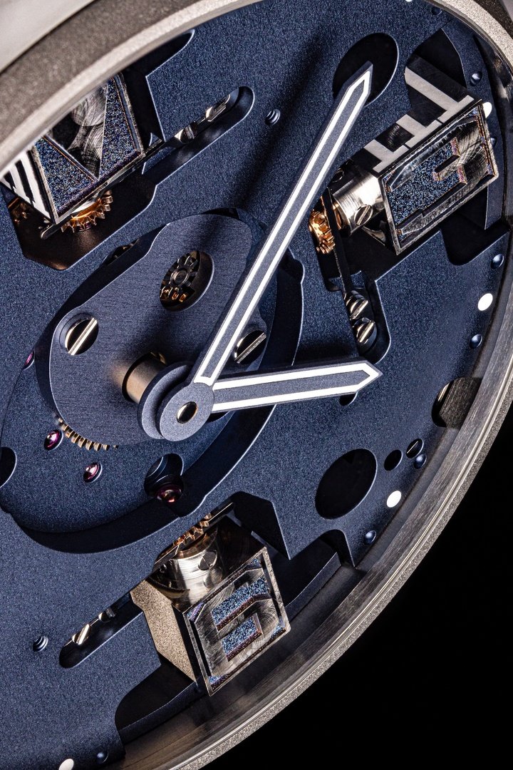 Close-up of the Meca Blue. The openworked dial reveals the complexity of the pivoting mechanisms for the indices, with Arabic numerals in brushed titanium.