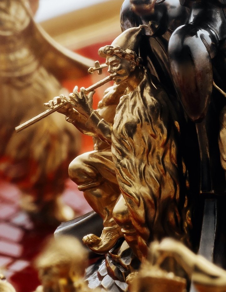 One of the musicians in the dial centre, his emotions conveyed in the intricate and detailed carving.